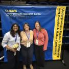 Students stand in front of a banner at the undergraduate research conference